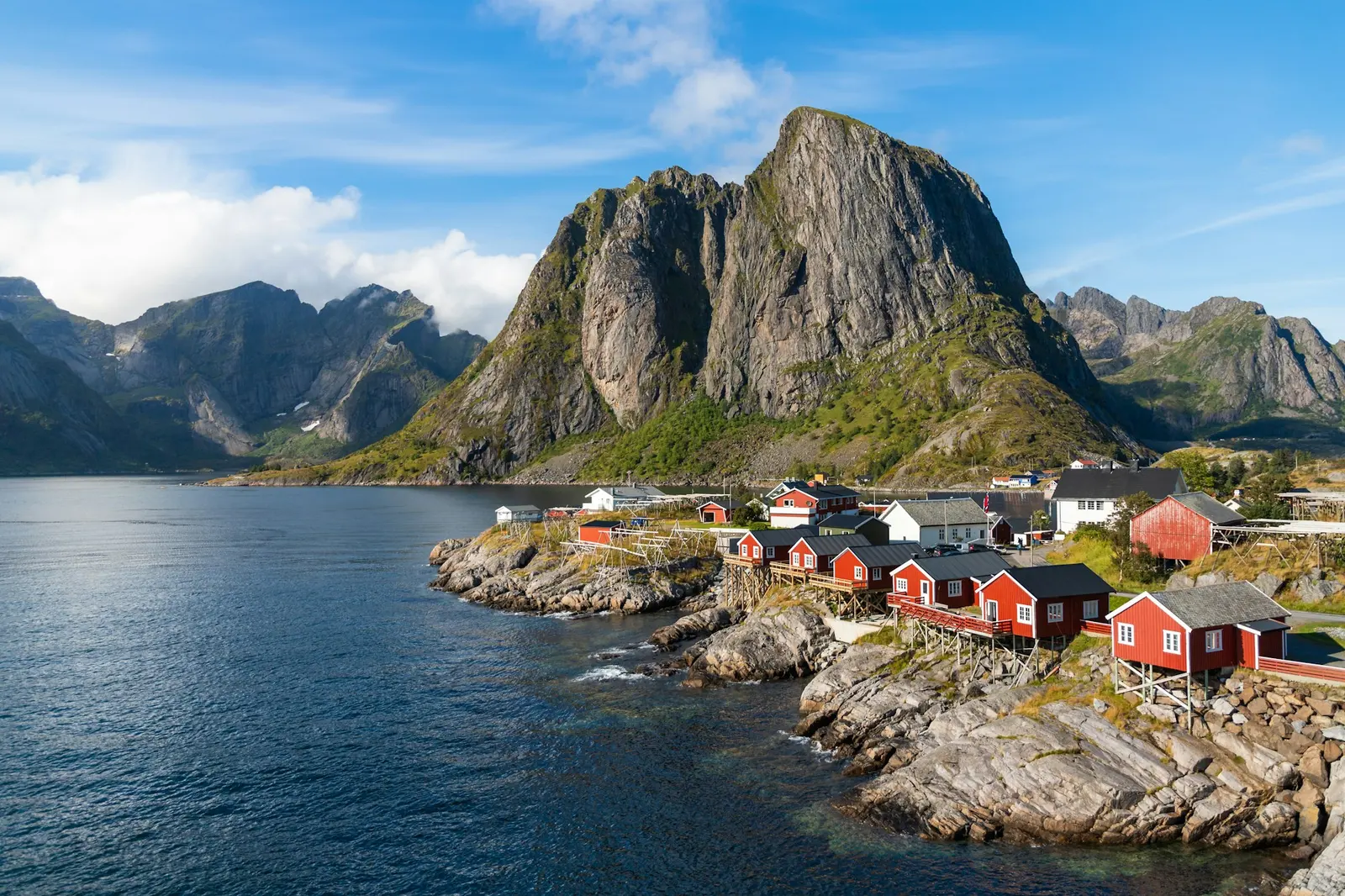 Houses at the water's edge below steep mountains in a Norwegian fjord